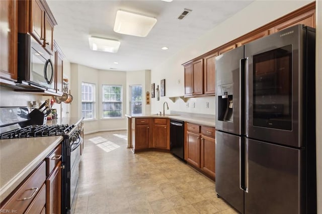 kitchen with visible vents, range with gas stovetop, a peninsula, black dishwasher, and stainless steel refrigerator with ice dispenser