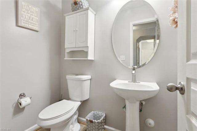 bathroom with baseboards and toilet