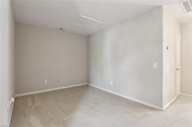empty room featuring light colored carpet, baseboards, attic access, and visible vents
