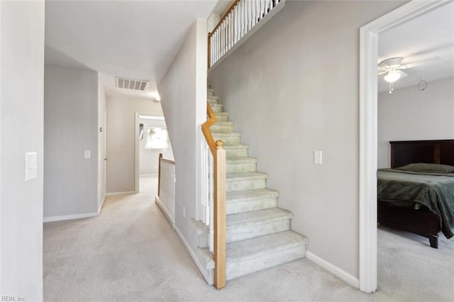 stairs featuring baseboards, visible vents, carpet, and ceiling fan