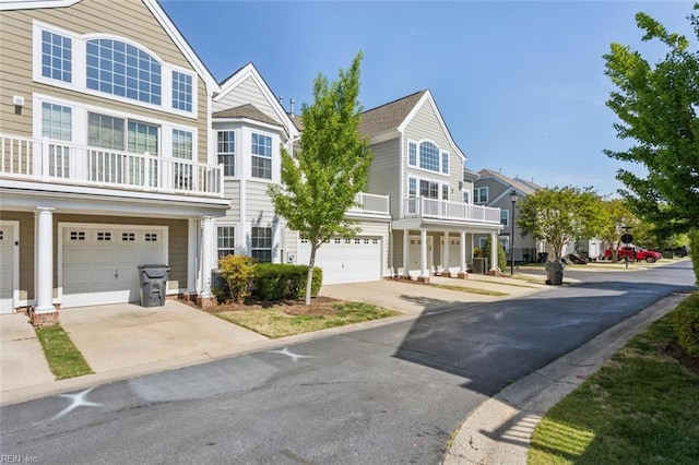 view of front of property with concrete driveway and a balcony