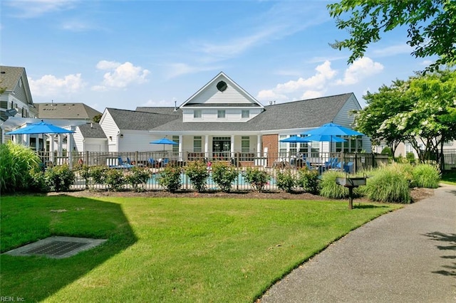 back of property featuring a yard, a fenced in pool, and fence