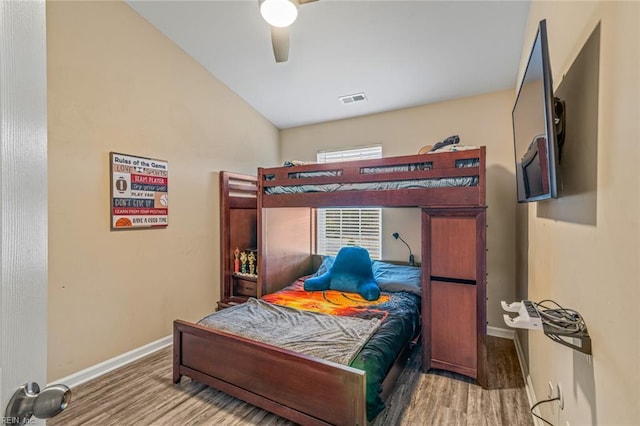 bedroom with vaulted ceiling, visible vents, baseboards, wood finished floors, and ceiling fan
