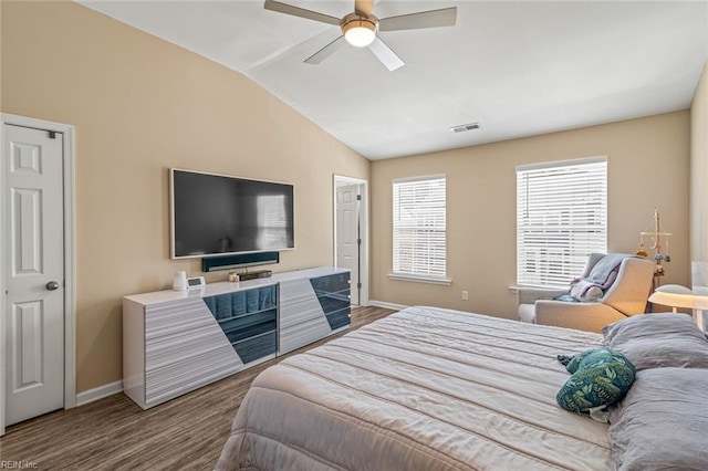 bedroom featuring lofted ceiling, a ceiling fan, baseboards, and wood finished floors