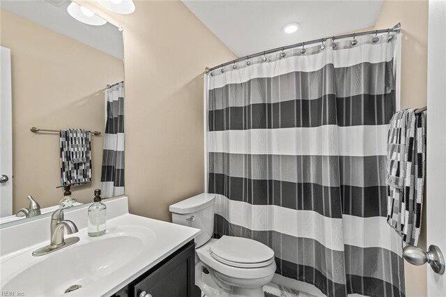 full bath with a shower with curtain, vanity, and toilet