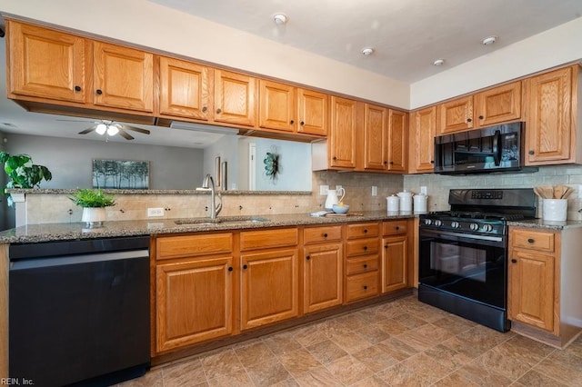 kitchen with backsplash, stone countertops, a sink, and black appliances