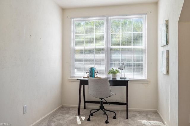 carpeted office space with plenty of natural light and baseboards
