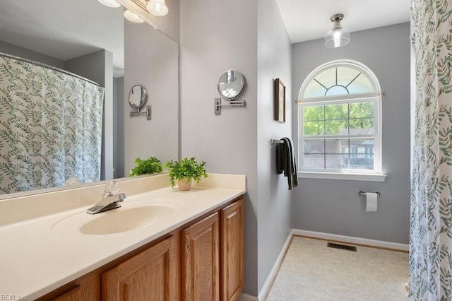 bathroom with baseboards, vanity, and visible vents