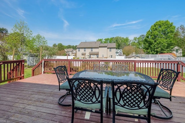 wooden deck with outdoor dining area and a residential view