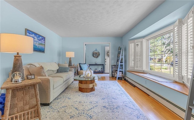 living room with a baseboard radiator, wood finished floors, and a textured ceiling