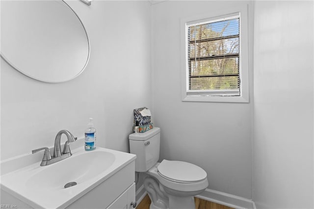 bathroom featuring baseboards, wood finished floors, vanity, and toilet