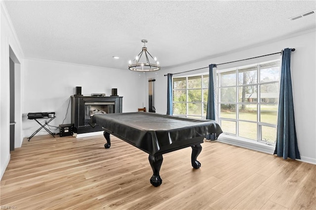 rec room with light wood finished floors, a textured ceiling, visible vents, an inviting chandelier, and billiards