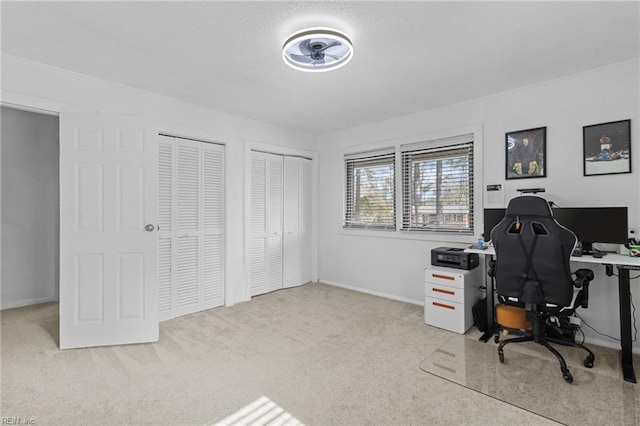 carpeted home office featuring baseboards
