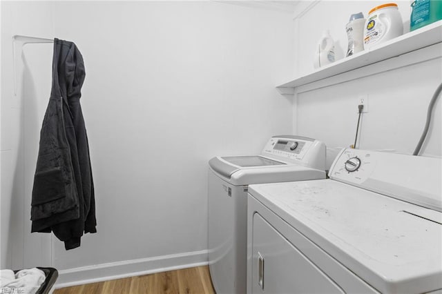 laundry area with washer and dryer, baseboards, laundry area, and light wood-style flooring