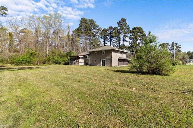 view of yard featuring a sunroom and stairway