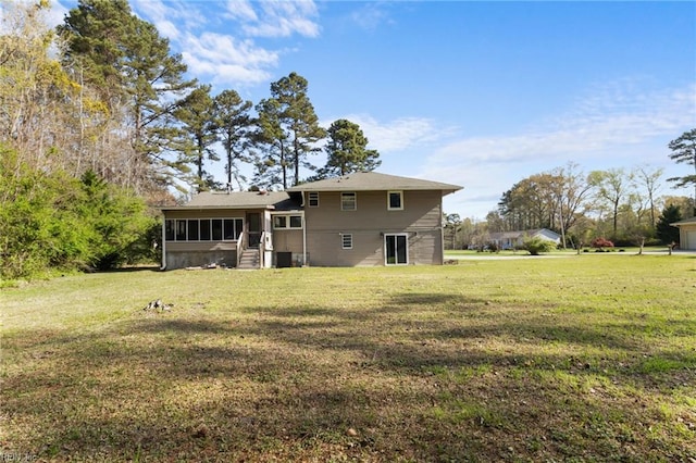 rear view of property featuring a lawn and a sunroom
