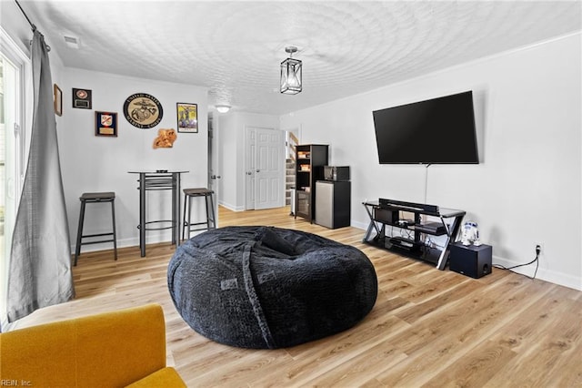 living room featuring baseboards, wood finished floors, and a textured ceiling