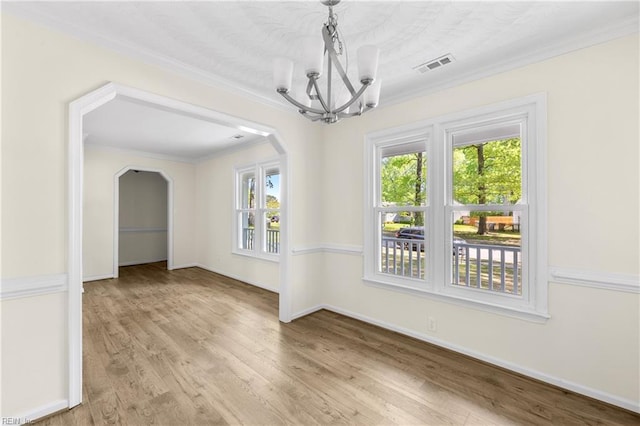 unfurnished dining area featuring wood finished floors, visible vents, a wealth of natural light, and a notable chandelier