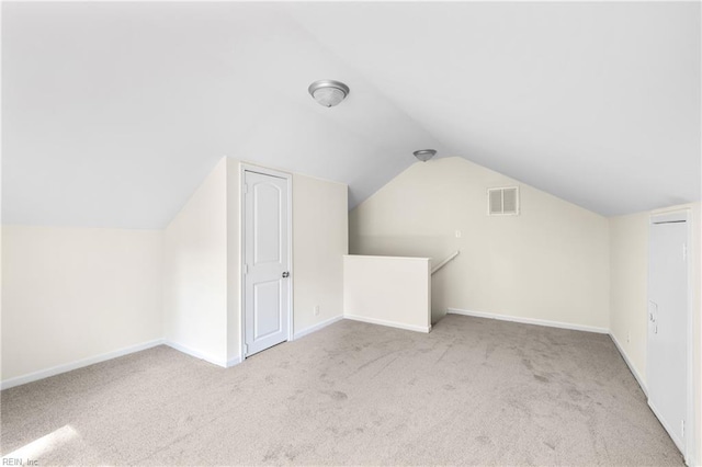 additional living space with carpet, visible vents, lofted ceiling, and baseboards