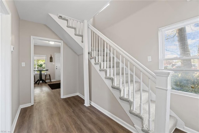 stairway with wood finished floors and baseboards