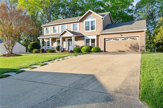 view of front of house featuring a porch, driveway, a front yard, and a garage