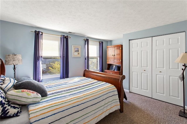 carpeted bedroom featuring a textured ceiling, a closet, and visible vents