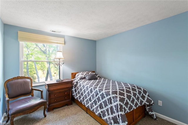 bedroom featuring baseboards, visible vents, a textured ceiling, and carpet flooring