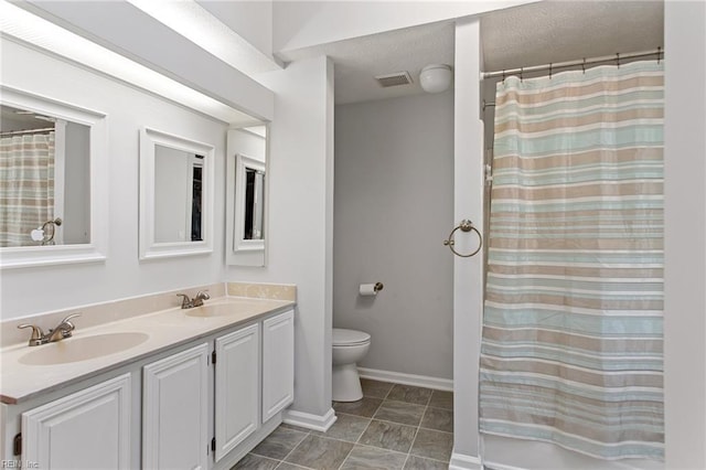 bathroom featuring toilet, a sink, visible vents, and double vanity