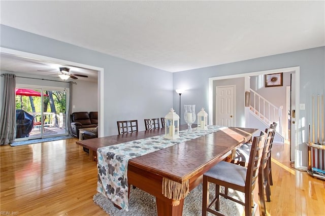 dining room featuring stairs, light wood-style floors, and ceiling fan