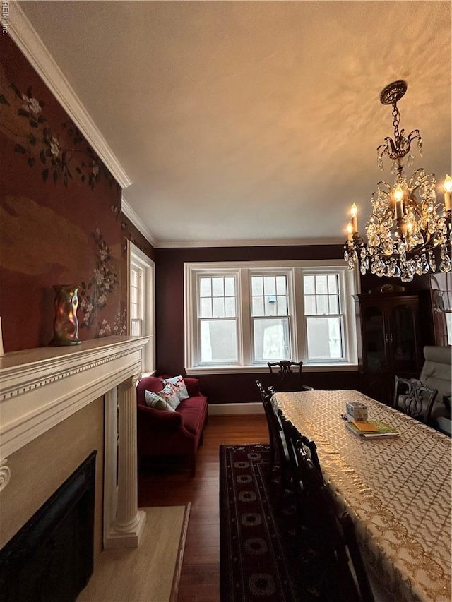 dining area featuring crown molding, dark wood finished floors, a glass covered fireplace, and a wealth of natural light