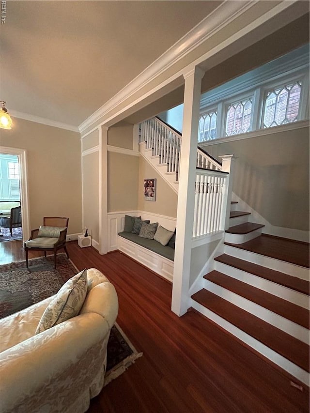 living area with stairs, crown molding, plenty of natural light, and wood finished floors