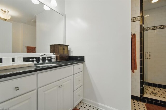 bathroom with vanity, baseboards, and a stall shower
