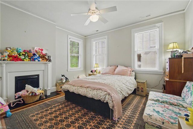 bedroom featuring crown molding, a fireplace, a ceiling fan, baseboards, and visible vents