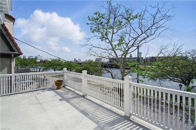 view of patio / terrace featuring a water view and a balcony