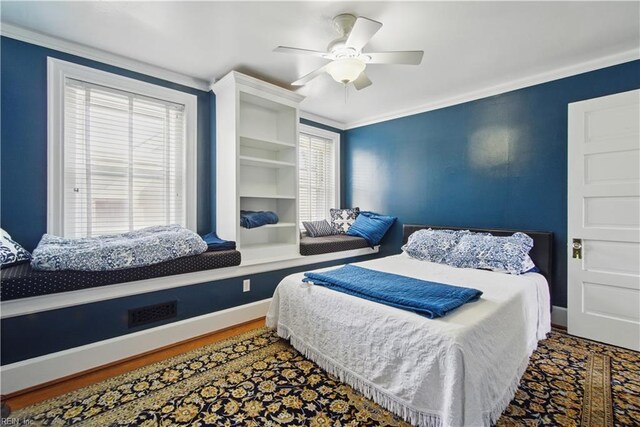 bedroom featuring baseboards, ornamental molding, a ceiling fan, and wood finished floors