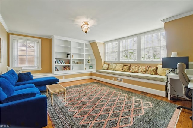 living area with crown molding, baseboards, and wood finished floors