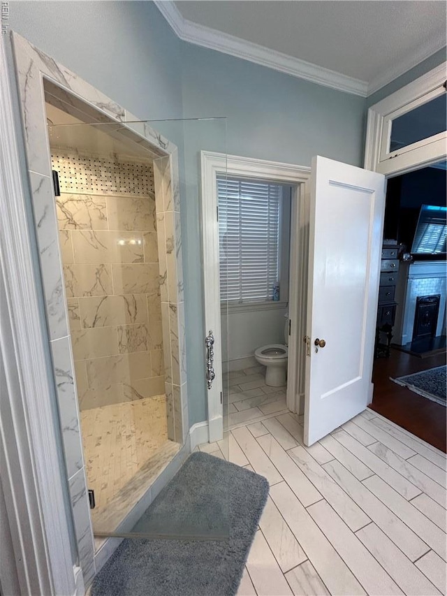 full bathroom with toilet, ornamental molding, marble finish floor, and a stall shower