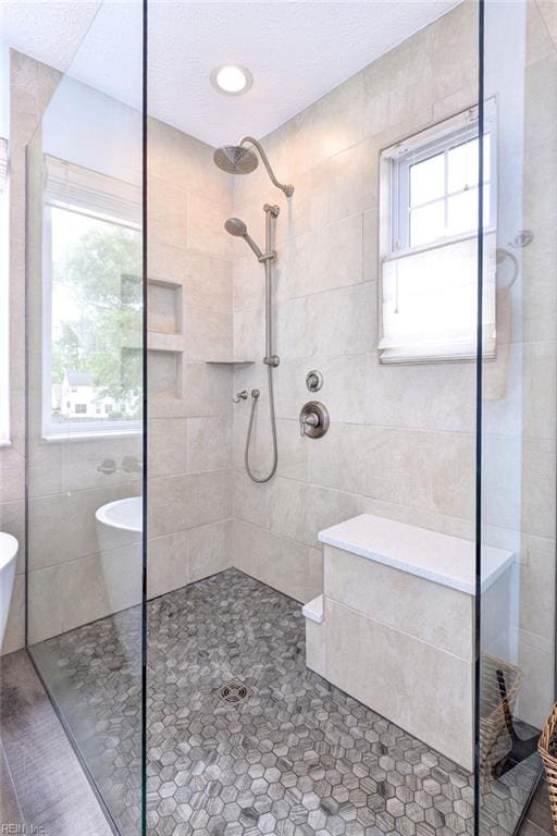 full bath with tile walls, tile patterned flooring, and a walk in shower