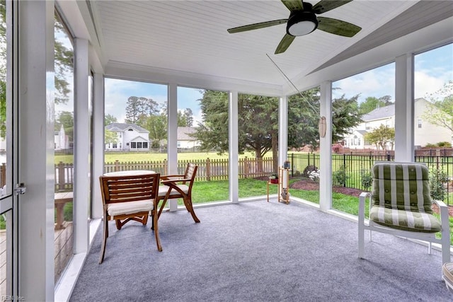 sunroom / solarium with plenty of natural light, a residential view, and ceiling fan