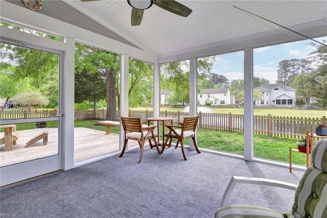 sunroom featuring ceiling fan and a water view