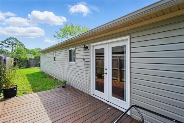 deck featuring a lawn, french doors, and fence