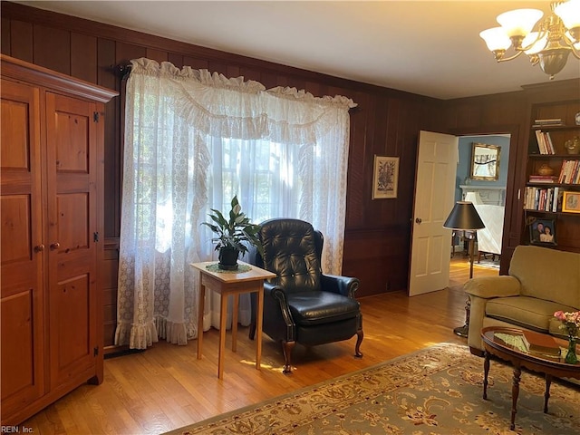 26060 Court St, Courtland, VA 23837 - sitting room featuring wooden walls, light wood finished floors, and a notable chandelier