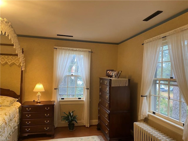 26060 Court St, Courtland, VA 23837 - bedroom with wood finished floors, radiator, baseboards, ornamental molding, and visible vents