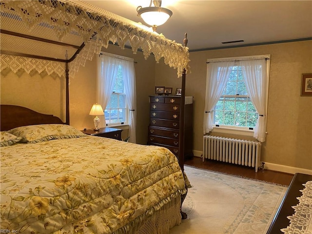 26060 Court St, Courtland, VA 23837 - bedroom with radiator heating unit, wood finished floors, visible vents, ornamental molding, and baseboards