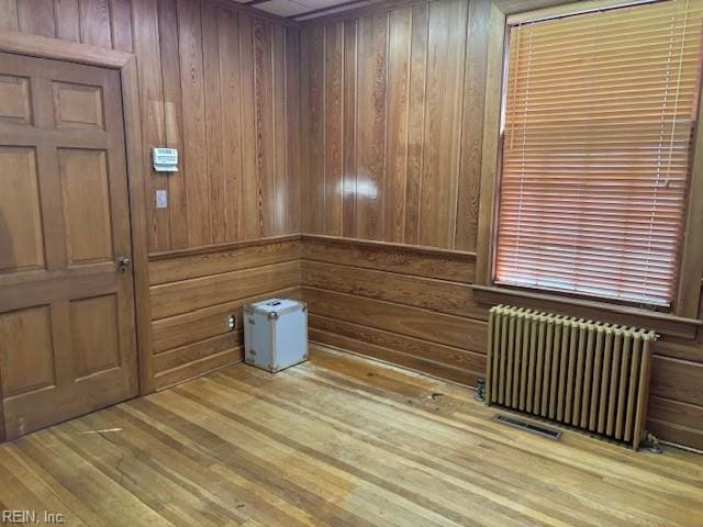 26060 Court St, Courtland, VA 23837 - spare room with radiator heating unit, wood finished floors, and wooden walls
