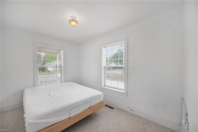 bedroom featuring baseboards, carpet flooring, and visible vents
