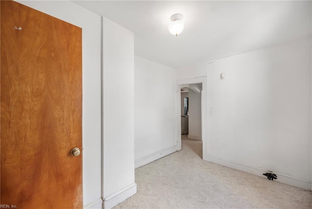 carpeted spare room featuring baseboards