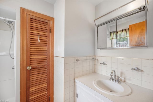 bathroom with tile walls, vanity, and a closet