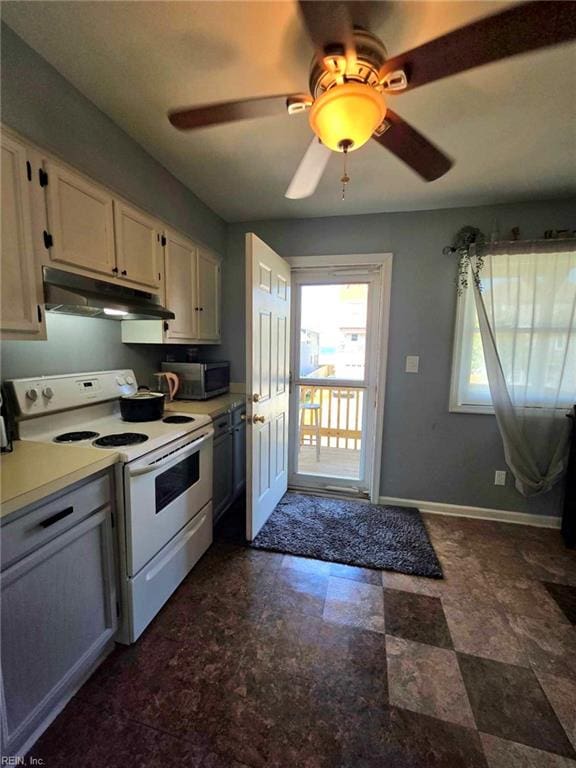 kitchen featuring under cabinet range hood, white range with electric stovetop, light countertops, stainless steel microwave, and baseboards