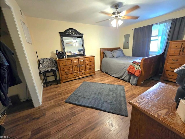 bedroom with ceiling fan, wood finished floors, and electric panel